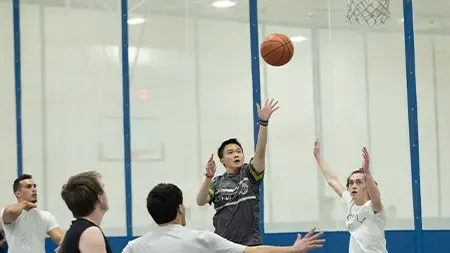 Group of male students playing intramural basketball game